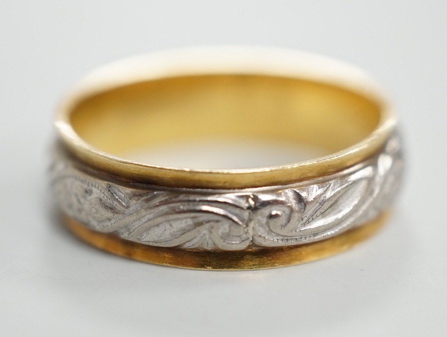 An engraved yellow and white metal band, size L, 3.7 grams.